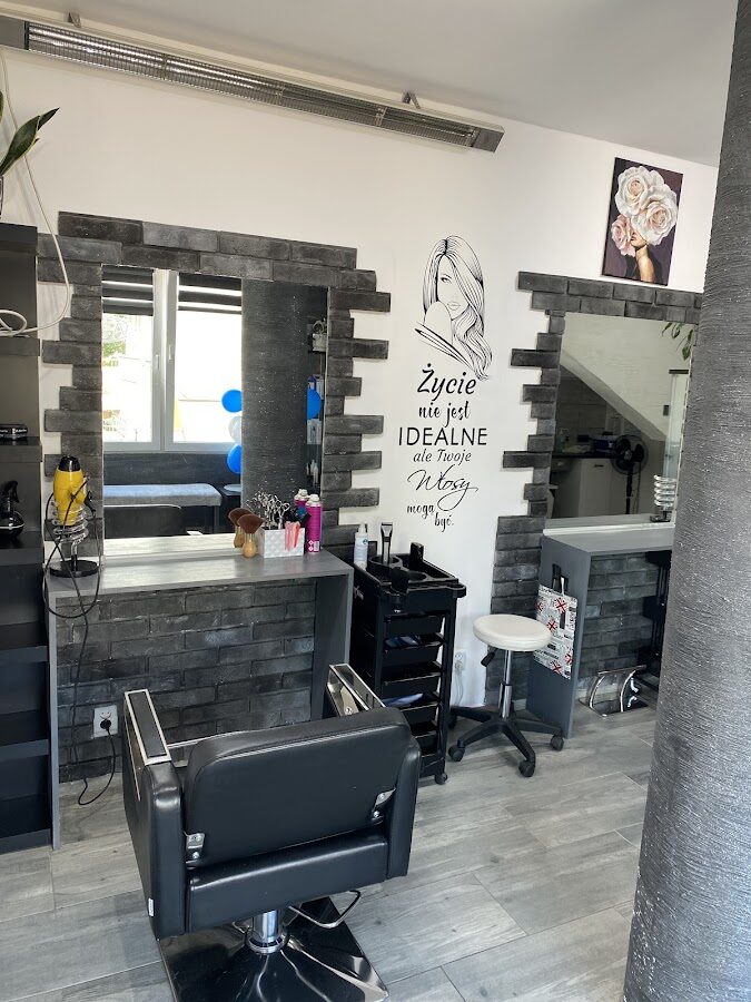 Stanowiska fryzjerskie z lustrami i produktami w salonie Pan & Pani